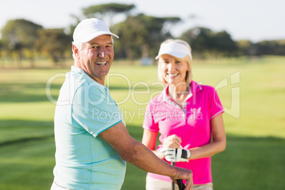 Portrait of happy mature golf player couple