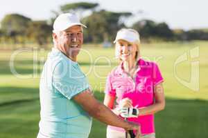 Portrait of happy mature golf player couple