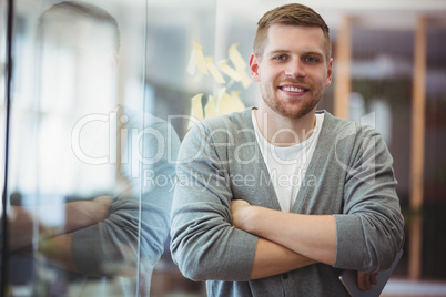 Portrait of businessman with arms crossed in office