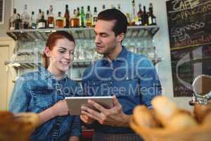 Young baristas with digital tablet at cafe