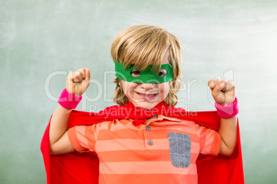 Happy boy dressed as superhero in classroom