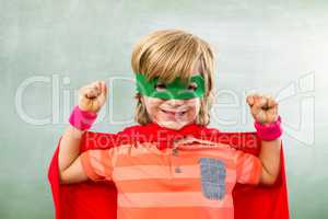 Happy boy dressed as superhero in classroom