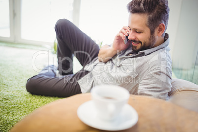 Young businessman talking on phone at creative office