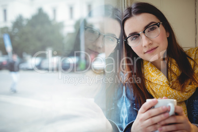 Portrait of beautiful woman sitting by window at cafe