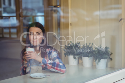 Thoughtful woman having coffee at cafe