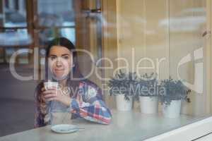 Thoughtful woman having coffee at cafe