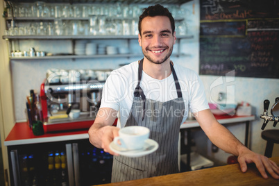 Portrait of confident barista serving coffee at cafe