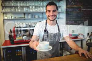 Portrait of confident barista serving coffee at cafe