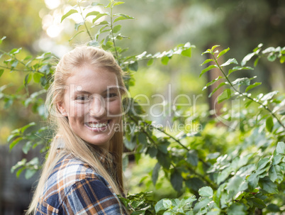 Happy female gardener standing by plants