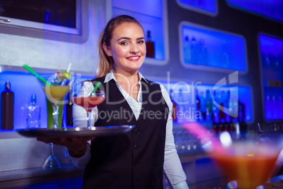 Portrait of beautiful bartender holding serving tray