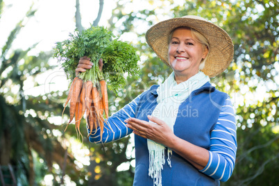 Portrait of happy customer with fresh carrots at greenhouse
