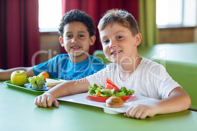 Smiling schoolboys having meal