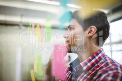 Businessman day dreaming while looking at sticky notes Businessman day dreaming while looking at sticky notes