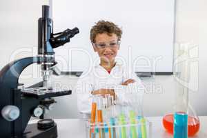 Portrait of boy standing table at laboratory