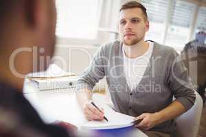 Young businessman holding notebook in office