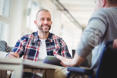 Front view of businessmen discussing with colleagues in office