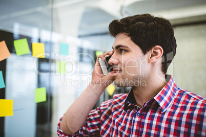 Businessman talking on phone while looking at sticky notes