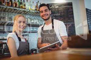 Portrait of confident colleagues with digital tablet