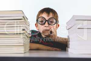 Boy with books on table in classroom