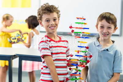 Cheerful boys holding DNA model