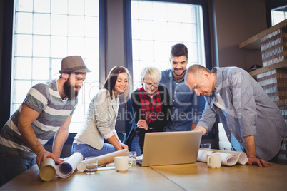 Creative business people discussing over laptop