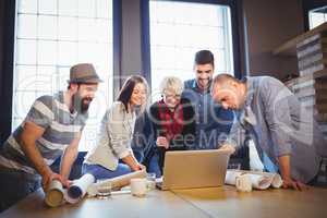 Creative business people discussing over laptop