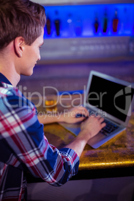 Man using laptop on bar counter
