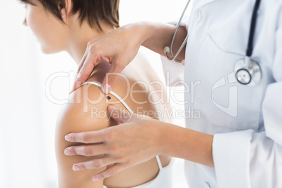 Midsection of doctor examining woman