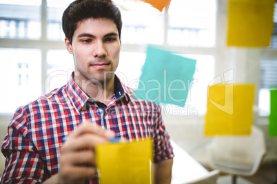 Businessman writing on sticky notes