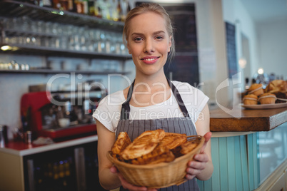 Portrait of confident waitress serving breads at coffee house