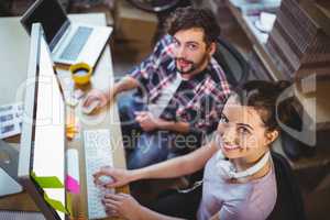 Portrait of happy coworkers working at computer desk