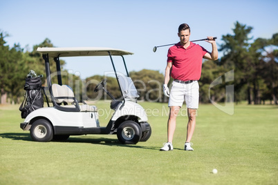 Handsome young man carrying golf club