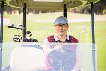 Golfer driving a golf buggy Golfer driving a golf buggy
