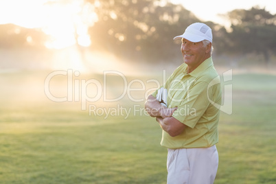 Portrait of happy golfer with arms crossed