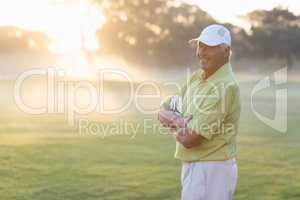 Portrait of happy golfer with arms crossed