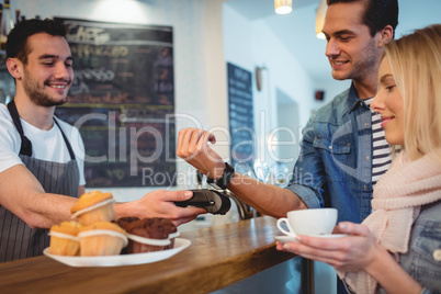 Happy customers with waiter at coffee shop