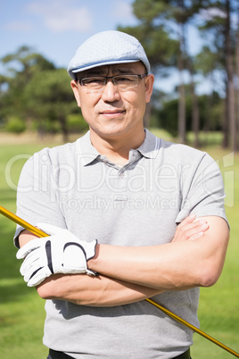 Portrait of happy golfer with arms crossed