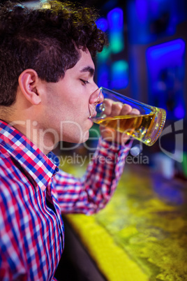 Man drinking beer at bar counter