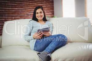 Portrait of smiling woman on sofa at home