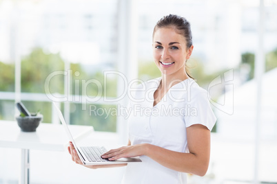 Portrait of smiling woman using laptop