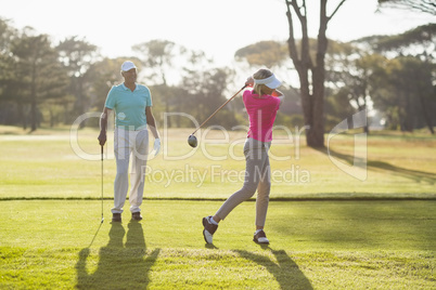 Mature golfer playing by man Mature golfer playing by man