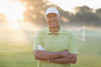 Portrait of smiling golfer with arms crossed