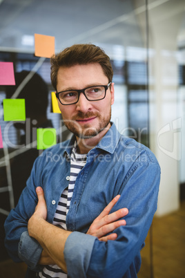 Thoughtful businessman standing with arms crossed