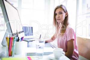 Confident graphic designer sitting at desk