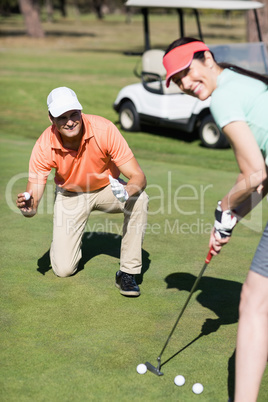 Portrait of smiling couple playing golf