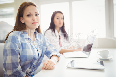 Young businesswoman with female colleague in creative office