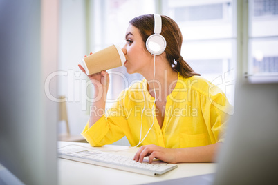 Executive drinking coffee while typing at office