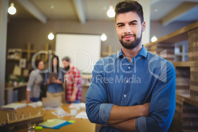 Confident creative businessman standing with arms crossed