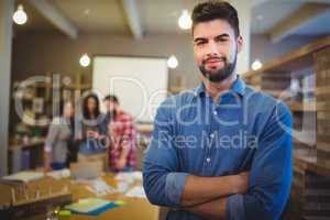 Confident creative businessman standing with arms crossed