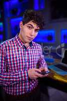 Portrait of man using mobile phone by bar counter